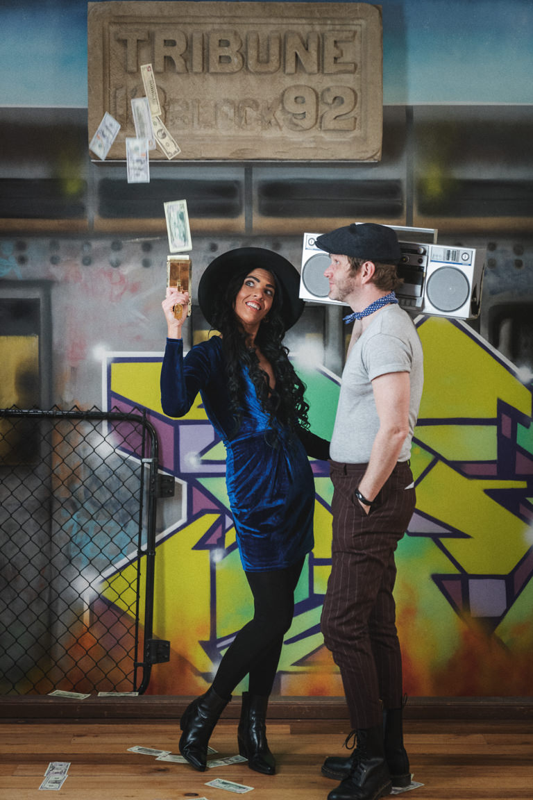 couple shooting money at graffiti wall at snap foto club