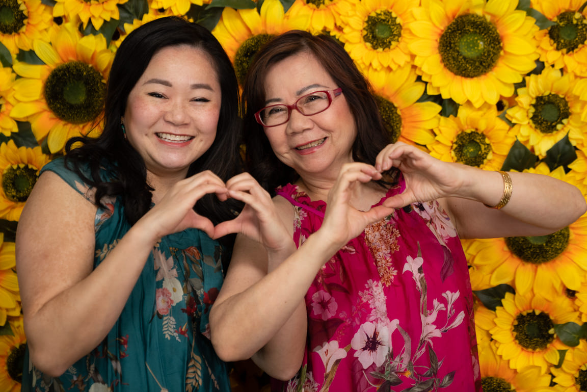 mom and daughter making heart shapes at snap foto club